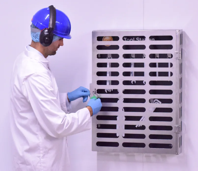 Operator securing a padlock on a perforated stainless steel tool cabinet door