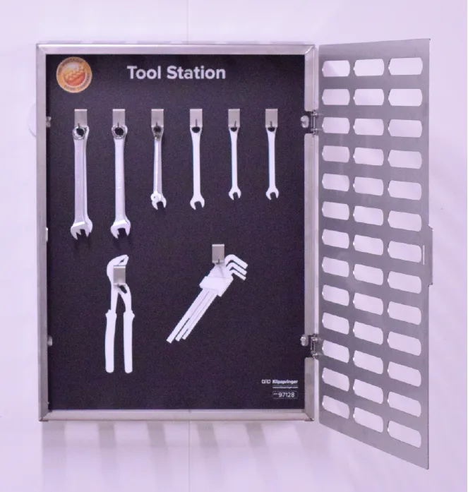 Front view of an open stainless steel tool cabinet with tool clips and shadow outlines