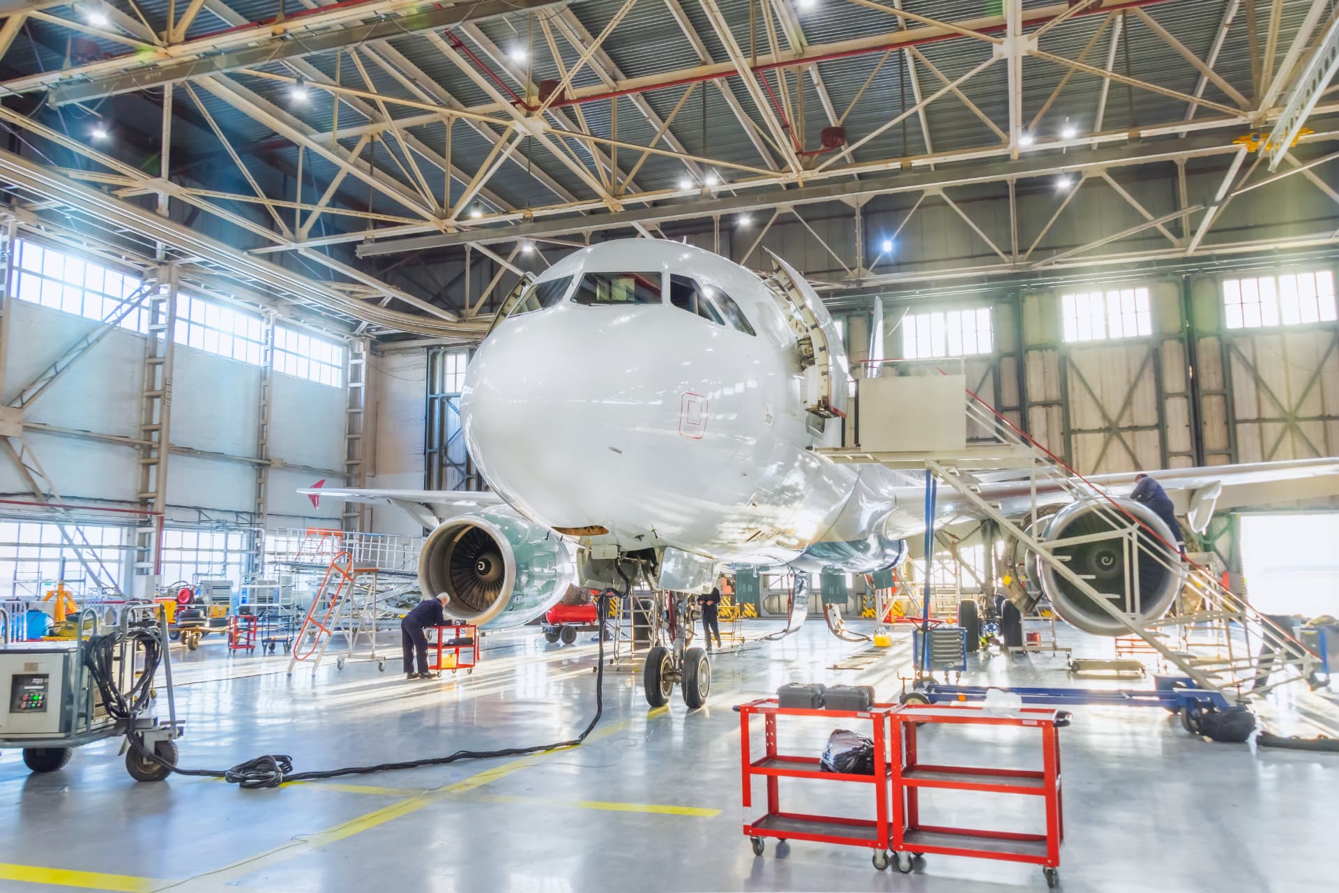 Passenger aircraft undergoing maintenance inside an aerospace hangar
